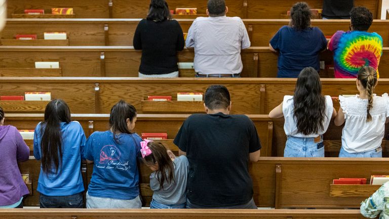 People pray Tuesday evening, May 24, 2022 at Sacred Heart Church in Uvalde after a gunman earlier in the day entered Robb Elementary School and killed at least 18 children and three adults.