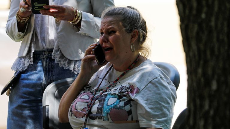 A woman on the phone outside the Ssgt Willie de Leon Civic Center, where students were transported from Robb Elementary School to be picked up after the shooting