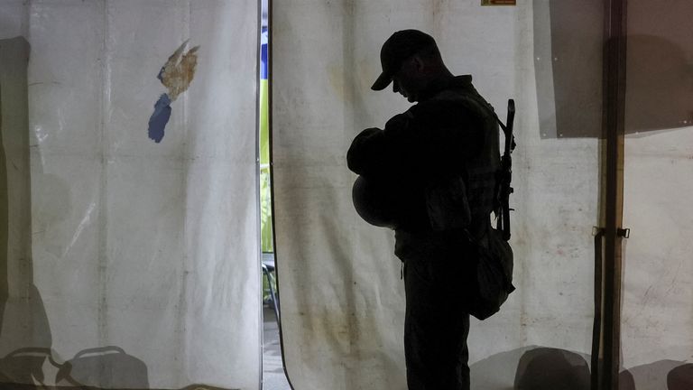 A Ukrainian police officer guards as refugees from the Azovstal steel plant in Mariupol arrive at a registration and humanitarian aid centre for internally displaced people, amid Russia&#39;s ongoing invasion of Ukraine, in Zaporizhzhia, Ukraine May 8, 2022. REUTERS/Gleb Garanich