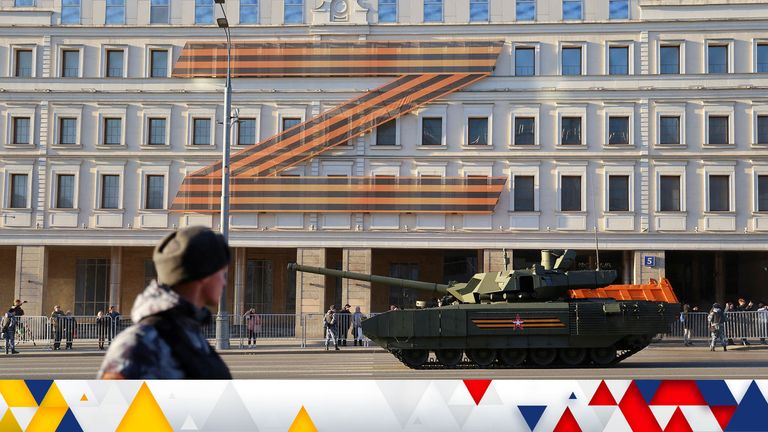 Russian service members drive a tank along a street during a rehearsal for the Victory Day military parade in Moscow