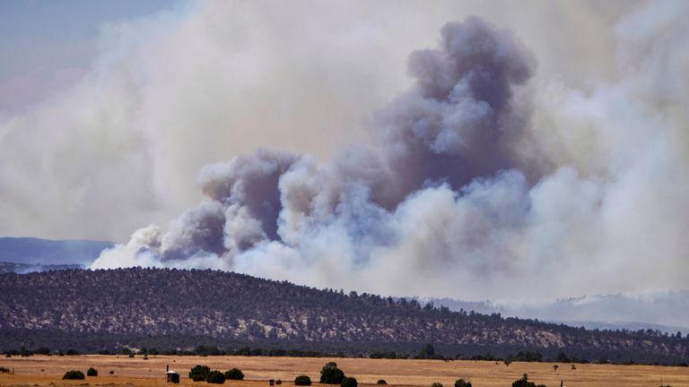 Smoke rises from wildfires near Las Vegas, N.M., Wednesday, May 4, 2022. Firefighters slowed the advance of the largest wildfire in the U.S. as heavy winds relented Wednesday, while President Joe Biden approved a disaster declaration that brings new financial resources to remote stretches of New Mexico devastated by fire since early April. (Roberto E. Rosales/The Albuquerque Journal via AP)