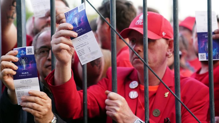Liverpool supporters show their tickets as they struggle to get into the Champions League final