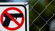 A detail view of a sign indicating no guns allowed is displayed on a fence, Sunday, June 19, 2022, in Houston. (Aaron M. Sprecher via AP)