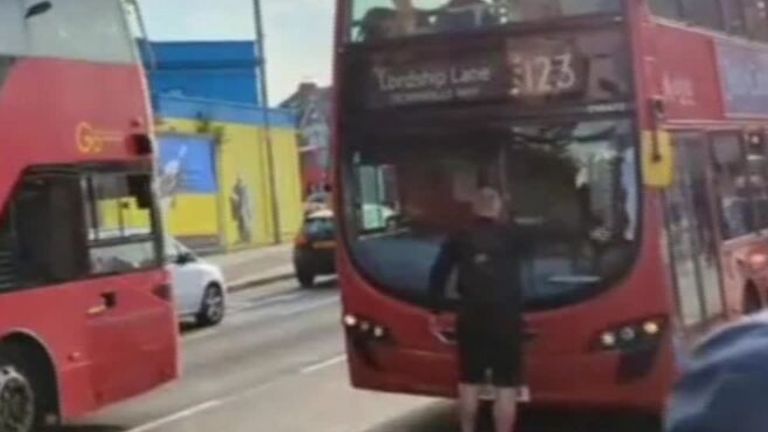 A frustrated commuter blocks the path of a bus at Blackhorse Road Station amid a tube and train strike