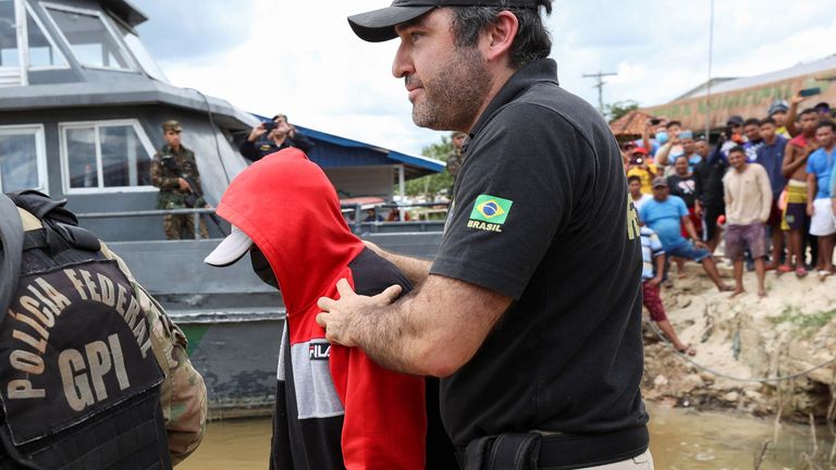 Federal Polis memurları, Atalaia'da Peru sınırına yakın, Amazon yağmur ormanlarının uzak ve kanunsuz bir bölümünde haber yaparken kaybolan kayıp İngiliz gazeteci Dom Phillips ve yerli uzman Bruno Pereira'nın kaybolmasına karışmakla suçlanan bir adama eşlik ediyor. Norte, Amazonas eyaleti, Brezilya, 15 Haziran 2022. REUTERS/Bruno Kelly