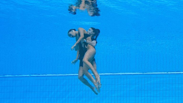 ABD (sağda) takımının bir üyesi, Budapeşte 2022 Dünya Su Sporları Şampiyonası'nda bayanlar solo serbest artistik yüzme finallerinde bir yangın sırasında ABD'li Anita Alvarez'i (solda) havuzun dibinden kurtardı. 22 Haziran 2022'de Budapeşte'deki Alfred Hajos Yüzme Kompleksi. (Fotoğraf: Oli SCARFF / AFP) (Fotoğraf, OLI SCARFF/AFP aracılığıyla Getty Images)