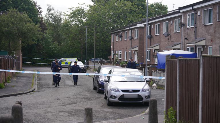 Police officers at the scene in Bednal Avenue, Miles Platting, Manchester, following the domestic incident where a 14-year-old boy died and his mother was injured in a "ferocious" stabbing on Thursday. A police spokesman said the suspected attacker, believed to have been known to the victims, should not be approached if seen by the public. Picture date: Friday June 10, 2022.