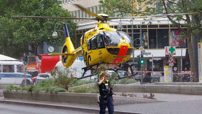 A police officer walks as a first-response helicopter takes off from the site where a car crashed into a group of people near Breitscheidplatz in Berlin, Germany, on June 8, 2022.  REUTERS/Michele Tantussia