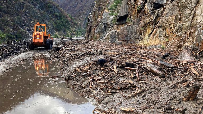 In this photo provided Caltrans, crews work to clear a multiple slides along Highway 70 in the Feather River Canyon near Belden, Calif., Sunday, June 12, 2022. A 50-mile (80-km) stretch of the highway was closed indefinitely on Monday after mud, boulders and dead trees inundated lanes during flash floods along a wildfire burn scar. There was no estimate for when the mountain route might reopen. (Caltrans via AP)