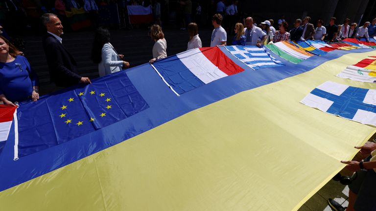Los legisladores europeos y los representantes ucranianos despliegan una bandera ucraniana de 30 metros de largo frente al Parlamento de la UE