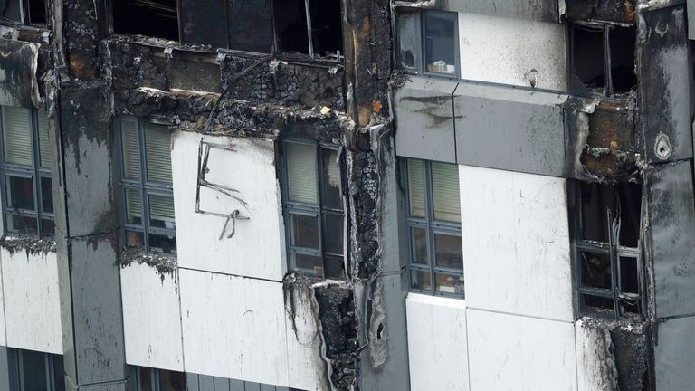 Fire-damaged cladding is seen on the lower floors of the Grenfell Tower after the blaze. Pic: AP