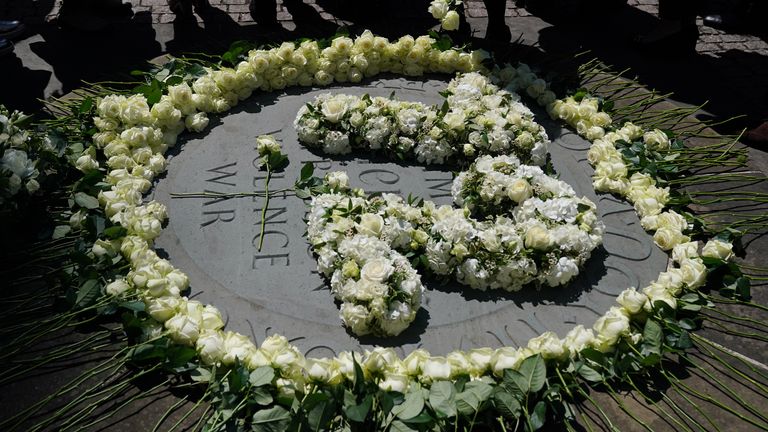 White roses are laid in the shape of the number 72 outside Westminster Abbey