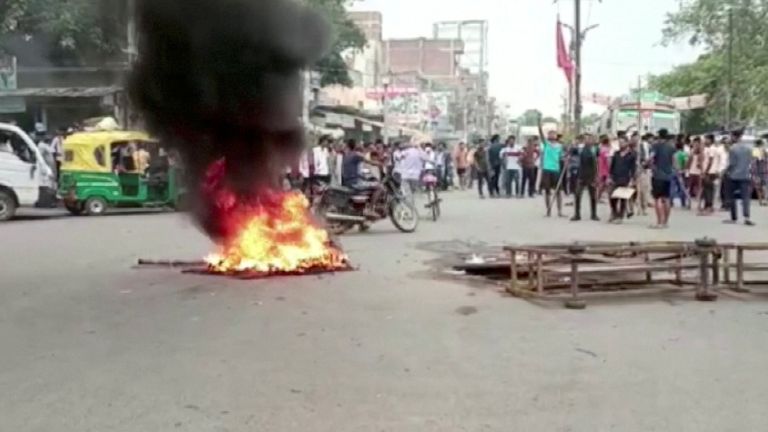 Protesters surround burning tires on the street as they protest "Agnipath Schema" to recruit personnel for the armed forces, in Jehanabad, Bihar, India June 16, 2022 in this still image obtained from a handout video.  ANI/Materials broadcast via REUTERS THIS IMAGE HAS BEEN PROVIDED BY THIRD PARTY.  CREDIT MANDATORY.  NO ANSWER.  NO STOCK.  INDIA OUT.  NO COMMERCIAL SALES OR EDITING IN INDIA.