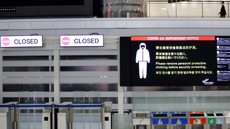 FILE PHOTO: A notice about COVID-19 safety measures is pictured next to closed doors at a departure hall of Narita international airport on the first day of closed borders to prevent the spread of the new coronavirus Omicron variant in Narita, east of Tokyo, Japan, November 30, 2021. REUTERS/Kim Kyung-Hoon/File Photo
