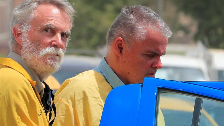 FILE PHOTO: Jim Fitton from Britain and Volker Waldmann from Germany, who are suspected of smuggling ancient artefacts out of Iraq, are escorted in handcuffs by Iraqi policemen, outside a court in Baghdad, Iraq, May 22, 2022. REUTERS/Thaier Al-Sudani/File Photo
