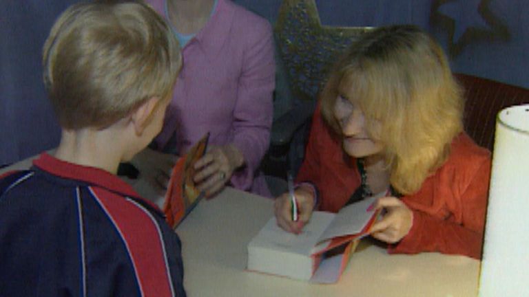 JK Rowling signing a copy of Harry Potter and the Philosopher's Stone 