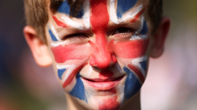 Joe Ferguson (9), with a Union Jack flag painted on his face, looks on, as royal enthusiasts gather along The Mall for the Queen&#39;s Platinum Jubilee celebrations in London, Britain June 2, 2022. REUTERS/Tom Nicholson
