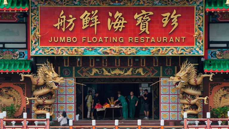 Staff members worship god on board of the Hong Kong&#39;s iconic Jumbo Floating Restaurant in Hong Kong, Tuesday, June 14, 2022. Hong Kong&#39;s iconic restaurant on Tuesday departed the city, after its parent company failed to find a new owner and lacked funds to maintain the establishment amid months of COVID-19 restrictions. (AP Photo/Kin Cheung)