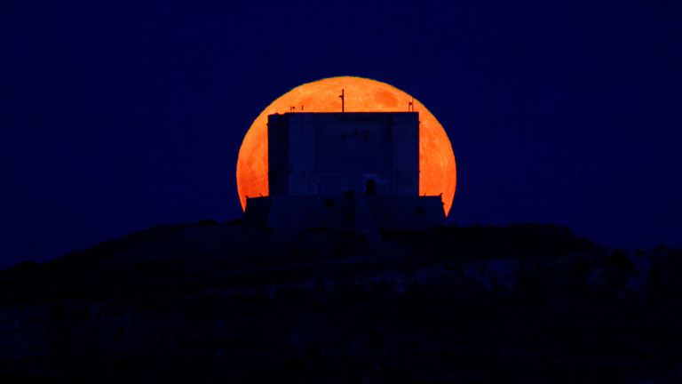 A full moon known as the "Strawberry Moon" rises behind the 17th century Santa Marija Tower on Comino island in the Maltese archipelago, Malta June 14, 2022. REUTERS/Darrin Zammit Lupi     TPX IMAGES OF THE DAY     
