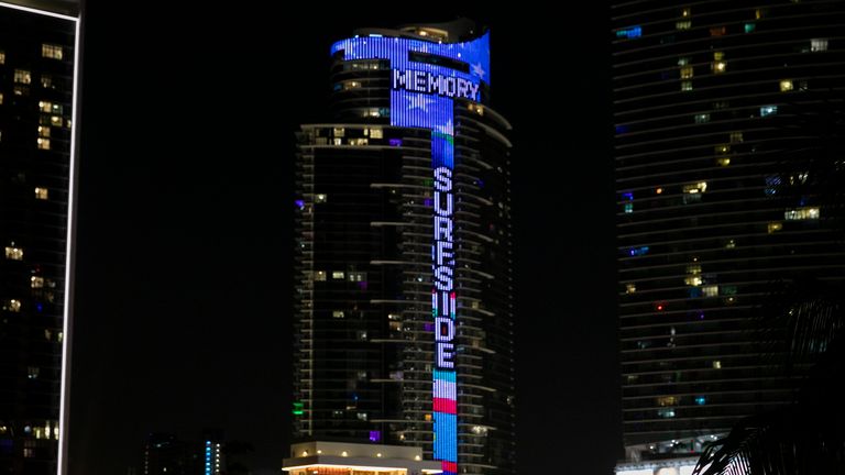 IMAGE DISTRIBUTED FOR WORLD SATELLITE TELEVISION NEWS - In observance of the one-year anniversary of the deadly Surfside Condominium Collapse, the 60-story Paramount Miami Worldcenter skyscraper lights-up the South Florida skyline with a massive digital memorial message to the families of the victims of the June 24, 2021 catastrophe. Through Paramount Miami&#39;s 700-foot center column appears the word, "Surfside." Across Paramount&#39;s 300-foot-wide by 100-foot-tall Skydeck Crown, shines the word, "Memory." It is emblazoned on an enormous electronic fluttering field of blue and sparkling white stars. "The Paramount tower lighting is a shining signal of sorrow," says Daniel Kodsi, CEO of Florida&#39;s Royal Palm Companies real estate development firm ... builder of the Paramount Miami Worldcenter. One year ago, the 12 story Champlain Towers, in the Miami suburb of Surfside, collapsed, killing 98 people. The Paramount Miami Worldcenter will illuminate downtown Miami during the pre-dawn and nighttime hours of June 23 through June 25, 2022. The superstructure will ignite at exactly at 1:22 a.m., on June 24, 2022, for a duration of 10-minutes ... marking the moment the Champlain Towers crumbled. (Eva Marie Uzcategui T./AP Images for World Satellite Television News)