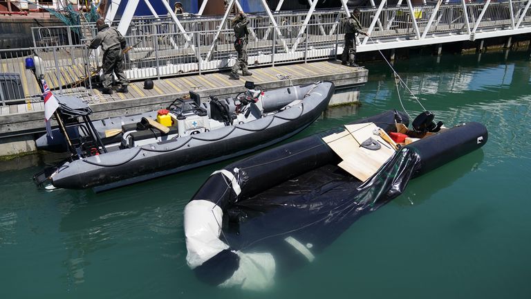 A partially submerged inflatable boat is brought into the marina after a group of people thought to be migrants are brought in to Dover, Kent, by Border Force, following a small boat incident in the Channel. Picture date: Tuesday June 14, 2022.
