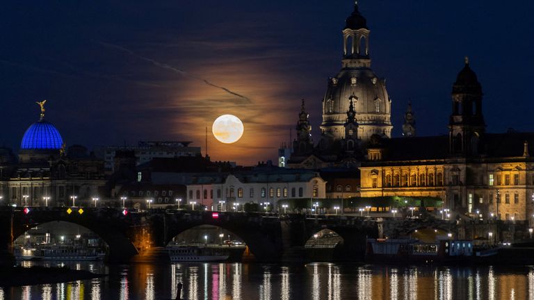 A full moon known as the "Strawberry Moon" rises behind the old town district, in Dresden, Germany, June 14, 2022. Picture taken June 14, 2022. REUTERS/Matthias Rietschel     TPX IMAGES OF THE DAY     