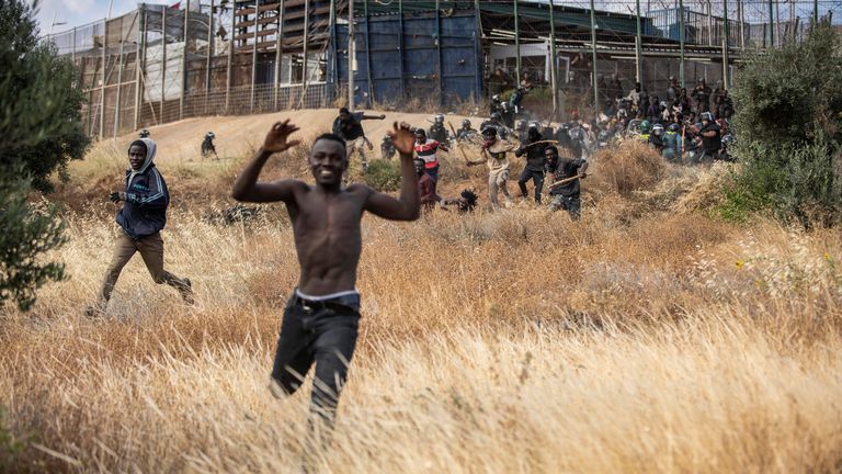 Migrants run on Spanish soil after crossing the fences separating the Spanish enclave of Melilla from Morocco in Melilla, Spain, Friday, June 24, 2022. Dozens of migrants stormed the border crossing between Morocco and the Spanish enclave city of Melilla on Friday in what is the first such incursion since Spain and Morocco mended diplomatic relations last month. (AP Photo/Javier Bernardo)