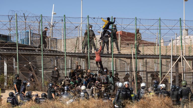 Migrants climb the fences separating the Spanish enclave of Melilla from Morocco in Melilla, Spain, Friday, June 24, 2022. Dozens of migrants stormed the border crossing between Morocco and the Spanish enclave city of Melilla on Friday in what is the first such incursion since Spain and Morocco mended diplomatic relations last month. (AP Photo/Javier Bernardo)