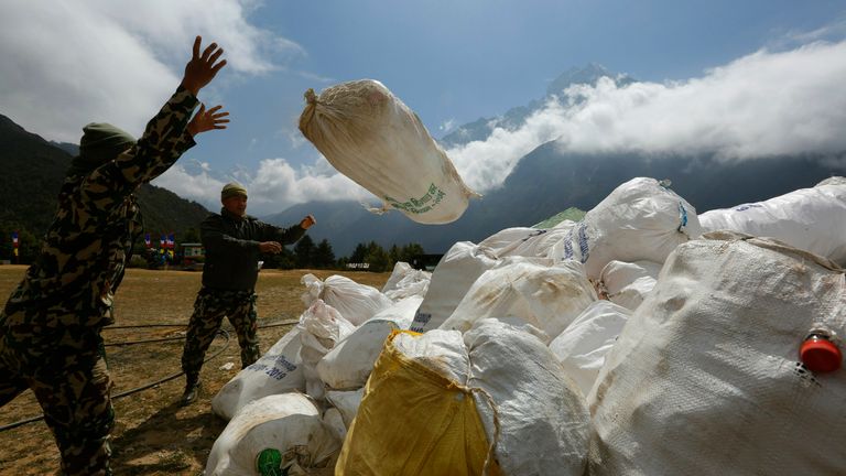 In this May 27, 2019 photo, Nepalese army men piled up the garbage collected from Mount Everest in Namche Bajar, Solukhumbu district, Nepal.  The record number of climbers on Mount Everest this season has left a cleanup crew grappling with how to clear away everything from abandoned tents to human waste that threatens drinking water.  (AP Photo/Niranjan Shrestha)