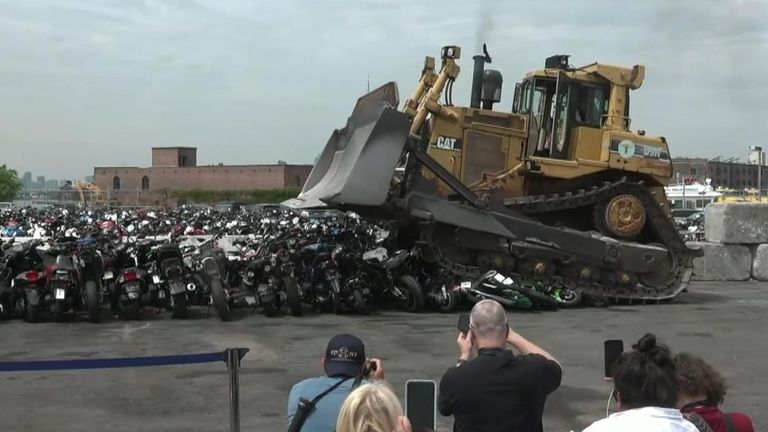 A bulldozer crushes bikes and ATVs seized by the NYPD.