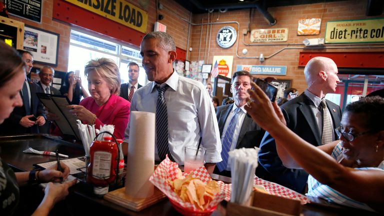 U.S. President Barack Obama and Democratic U.S. presidential candidate Hillary Clinton stop to order take-out dinners and greet people at a barbecue restaurant after a campaign rally in Charlotte, North Carolina, U.S. July 5, 2016. REUTERS/Jonathan Ernst