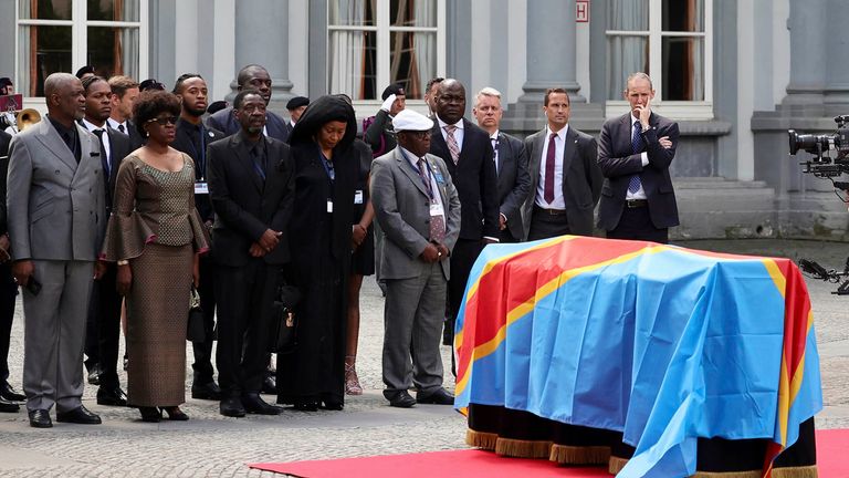 Patrice Lumumba'nın çocukları, soldan sağa, Roland, Juliana ve Francois, 20 Haziran 2022 Pazartesi günü Brüksel'deki Egmont Sarayı'nda düzenlenen bir tören sırasında Patrice Lumumba'nın cenazesinin bulunduğu tabutun yanında duruyorlar. Pazartesi günü, altmıştan fazla Kongo'nun demokratik yollarla seçilmiş ilk başbakanı Patrice Lumumba'nın ölümünden bir yıl sonra, Belçika'da düzenlenen resmi bir törenle çocuklarına cenazesi teslim edildi.  (AP Fotoğrafı/Olivier Matthys) Resim:AP