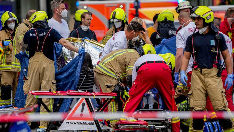 Kurtarma görevlileri, 8 Haziran 2022 Çarşamba, Almanya, Berlin'in merkezinde bir arabanın kalabalığın üzerine çarpması sonucu yaralı bir kişiye yardım ediyor. (AP Photo/Michael Sohn) PIC:AP