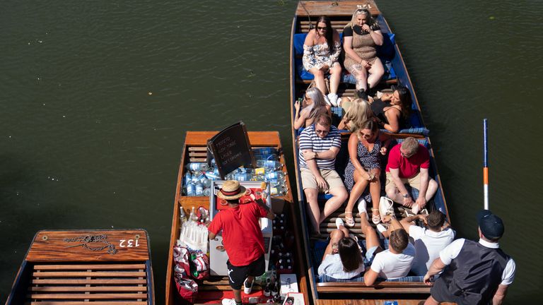 As bebidas são servidas às pessoas que aproveitam o clima quente enquanto navegam no rio Cam em Cambridge.  Data da foto: quinta-feira, 16 de junho de 2022.