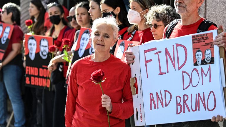Sian Phillips together with Gareth Phillips, siblings of missing journalist Dom Phillips hold a placard and a rose, as demonstrators protest following the disappearance, in the Amazon, of their brother Dom Phillips and campaigner Bruno Araujo Pereira, outside the Brazilian Embassy in London, Britain, June 9, 2022. REUTERS/Toby Melville

