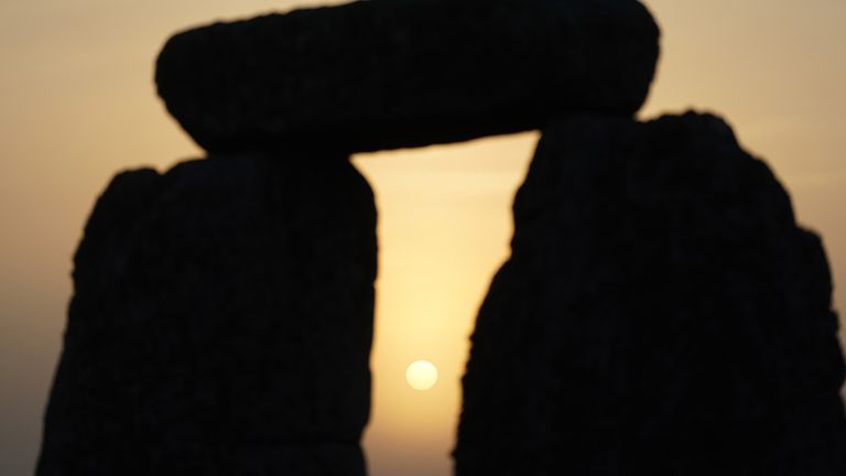 The sun begins to rise behind stones during the Summer Solstice at Stonehenge in Wiltshire. Picture date: Tuesday June 21, 2022.