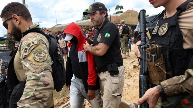 Federal police officers escort a man accused to be involved in the disappearance of British journalist Dom Phillips and indigenous expert Bruno Pereira