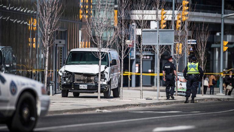Police are seen near a damaged van in Toronto after a van mounted a sidewalk crashing into a number of pedestrians on Monday, April 23, 2018. Pic: AP