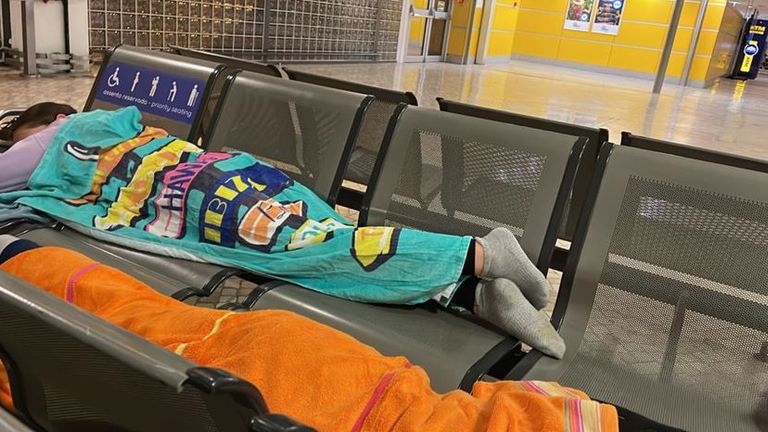 नाओमी थॉमस के दत्तक बच्चे, अल्फी और एनी, फ़ारो हवाई अड्डे पर तौलिये के नीचे सोते हैं।  शनिवार शाम को लिवरपूल के लिए आसान जेट उड़ान रद्द करने के बाद पुर्तगाल में