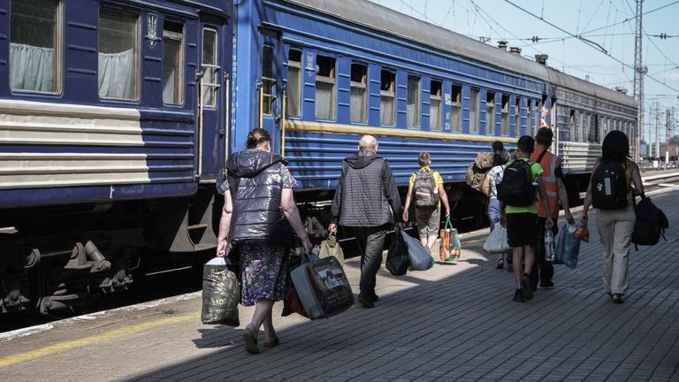 Families walk to join a train in a station in east Ukraine
