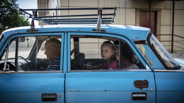 A family arrive at a station by car in east Ukraine