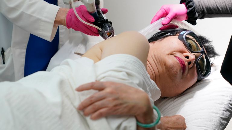 Kim Phuc receives a laser treatment by Dr. Jill Waibel, left, at the Miami Dermatology and Laser Institute, Tuesday, June 28, 2022, in Miami. Phuc was the subject 50 years ago of the Pulitzer Prize-winning "Napalm Girl" photo by retired AP photographer Nick Ut. She has been treated since 2015 pro bono at the institute for scars suffered in the June 8, 1972, firebombing of her village during the Vietnam War. (AP Photo/Lynne Sladky)