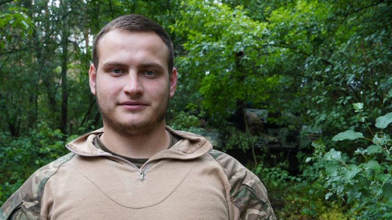 Vitalii Timoshuk, the Commander, wears a khaki shirt and has a hidden tank over his left shoulder