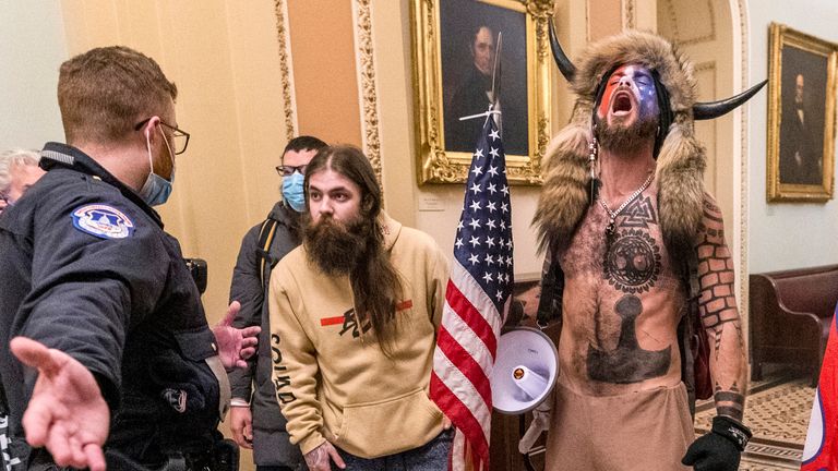 FILE - In this Wednesday, Jan. 6, 2021 file photo, supporters of President Donald Trump, including Jacob Chansley, right with fur hat, are confronted by U.S. Capitol Police officers outside the Senate Chamber inside the Capitol in Washington. More than 800 people across the U.S. have been charged in the Jan. 6 riot at the Capitol that left officers bloodied and sent lawmakers running in fear, and federal authorities continue to make new arrests practically every week. (AP Photo/Manuel Balce Ceneta, File)