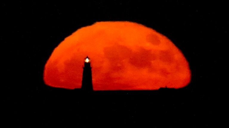 A full moon rises behind the Boston Light, late Tuesday, June 14, 2022, in Winthrop, Mass. The moon reached its full stage Tuesday, during a phenomenon known as a supermoon because of its proximity to Earth, and it is also labeled as the "Strawberry Moon" because it is the full moon at strawberry harvest time. (AP Photo/Julio Cortez)
PIC:AP
