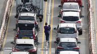 A woman carries a young child through the check-in lanes of cars waiting to enter the Port of Dover in Kent as families embark on summer getaways following the start of holidays for many schools in England and Wales. Picture date: Thursday July 28, 2022.

