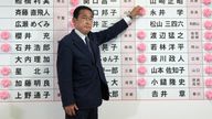 Prime Minister Fumio Kishida places a red paper rose on an LDP candidate&#39;s name to indicate a victory in the upper house election