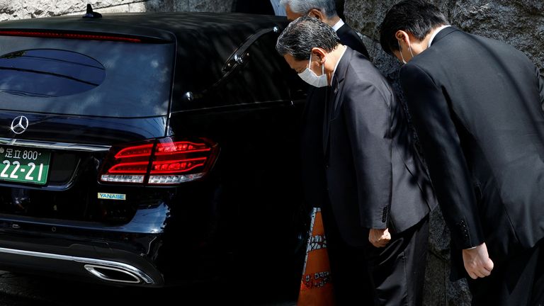 LDP representatives pray in front of a car believed to be carrying the body of former Japanese Prime Minister Shinzo Abe