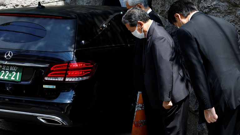 LDP officials pray with the vehicle believed to be carrying the body of former Japanese Prime Minister Shinzo Abe