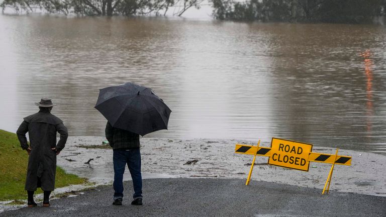 Residents look at the flooded road outside their homes at Richmond on the outskirts of Sydney, Australia, Tuesday, July 5, 2022. Hundreds of homes have been inundated in and around Australia&#39;s largest city in a flood emergency that was threatening 45,000 people, officials said on Tuesday. (AP Photo/Mark Baker)